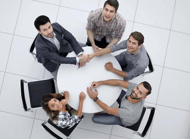 Вид сверхутворческая бизнес-группа сидит за круглым столомфото с копией пространства