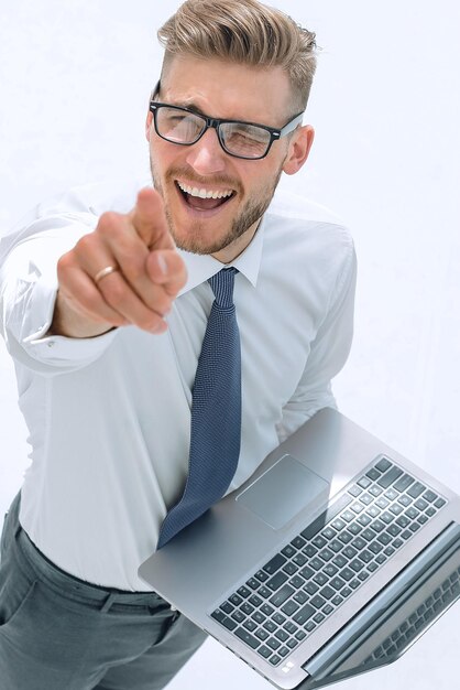 Top viewsmiling businessman with laptop pointing at you