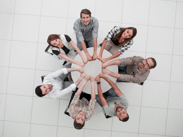 Top viewthe smiling business team folded their hands forming a circlethe concept of teamwork