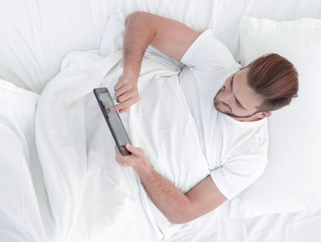 Top viewyoung man typing on a digital tablet