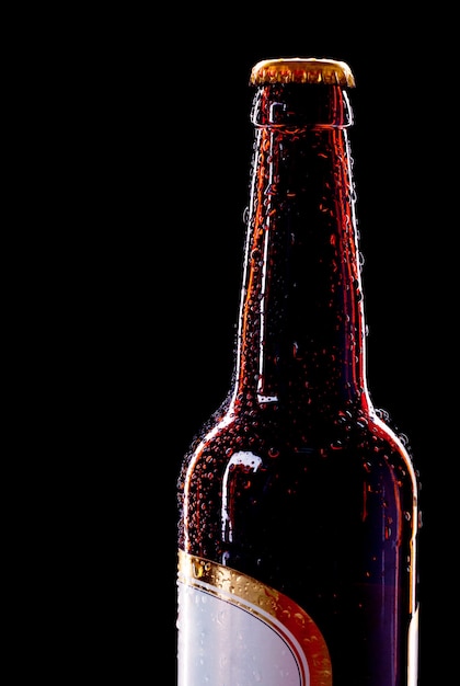 Top of wet beer bottle isolated on black