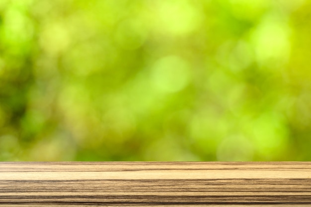 Top wood table on blurred green bokeh background from tree in the park. Beautiful image. Copy space.