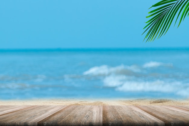 Top of wood table with blurred sea and palm tree background.