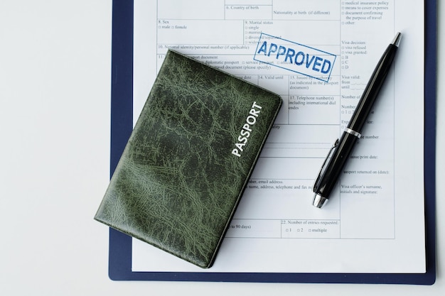 Topdown plat leggen van paspoort in donkergroen lederen omslag visumaanvraagpapier met goedgekeurd