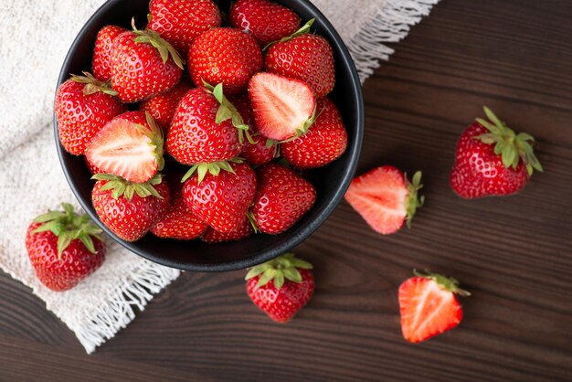 Topdown shot of strawberry on black wooden table Fresh tasty strawberry