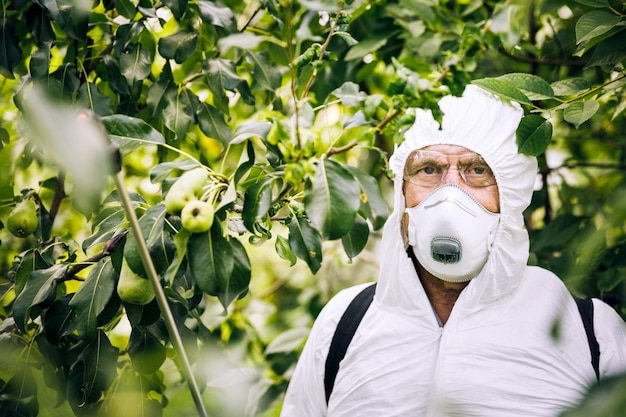Тема промышленного сельского хозяйства Человек распыляет токсичные пестициды или инсектициды на плантации Борьба с сорняками