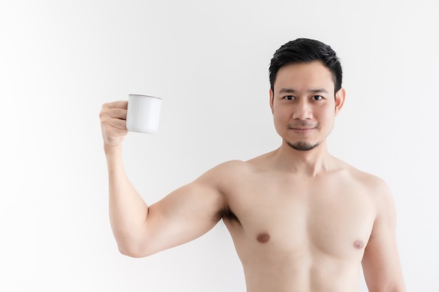 Topless gezonde man drinkt de gezonde koffie op geïsoleerde muur.