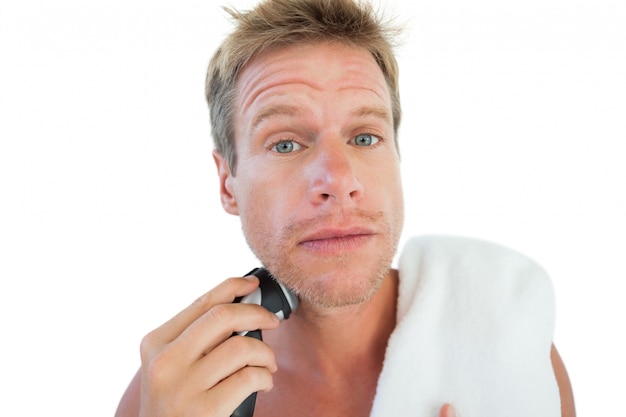 Topless man shaving his beard