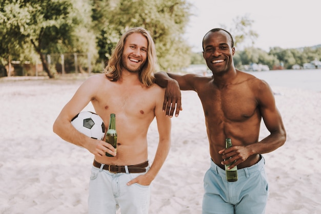 Topless Men with Football Smiling on Beach