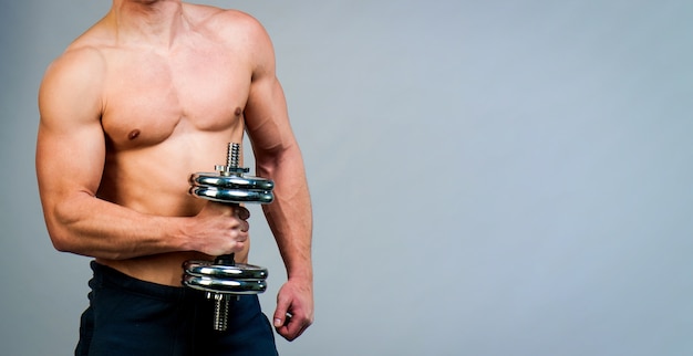 Topless muscular man with weights isolated