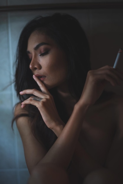 topless woman holding cigarette