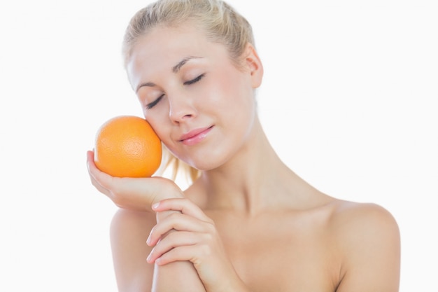 Topless woman holding orange