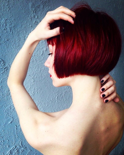 topless woman with redhead against wall