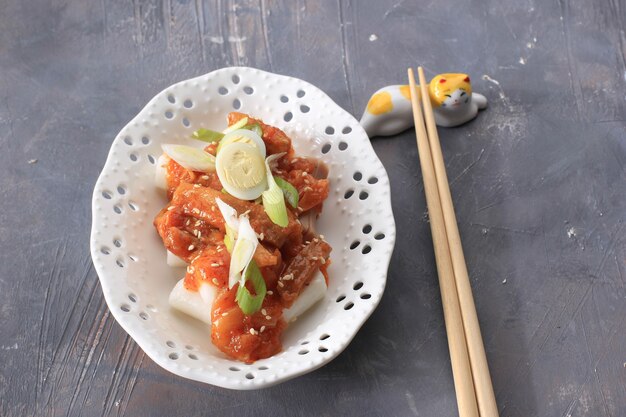 Topokki or Tteokbokki is Stir-fried Rice Cake with Vegetables and Fish Cake in Spicy Sauce Top with Sesame Seed, Famous and Popular Korean Street Food