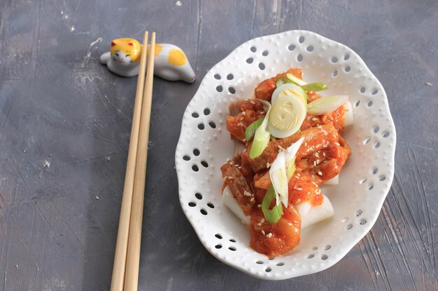 Topokki or Tteokbokki is Stir-fried Rice Cake with Vegetables and Fish Cake in Spicy Sauce Top with Sesame Seed, Famous and Popular Korean Street Food