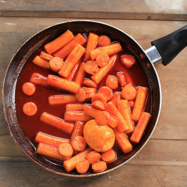 Topokki o tteokbokki è una torta di riso saltata in padella con verdure e torta di pesce in salsa piccante con semi di sesamo, famoso e popolare cibo di strada coreano