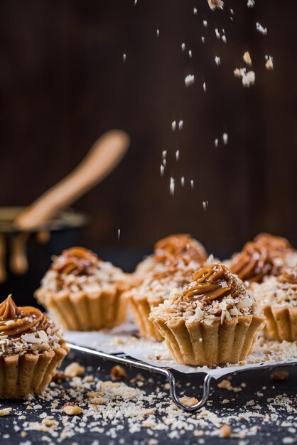 Topping salted caramel cupcakes with walnuts