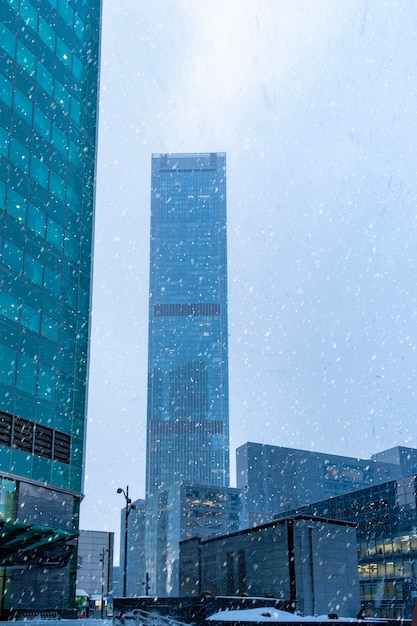The tops of modern corporate buildings in snowfall Low angle view of skyscrapers