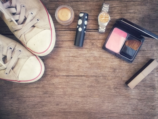 Topview of cosmetic makeup collection warm tone for sumer look on wood table background.