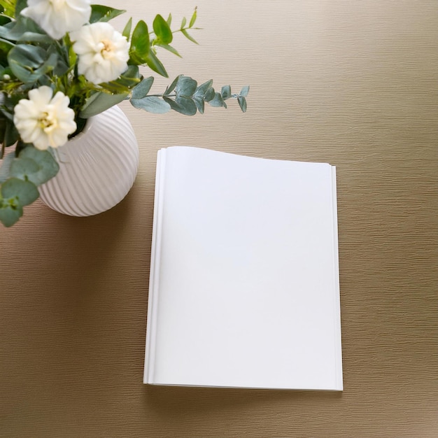 topview mockup of a blank magazine on a desk with a flower vase