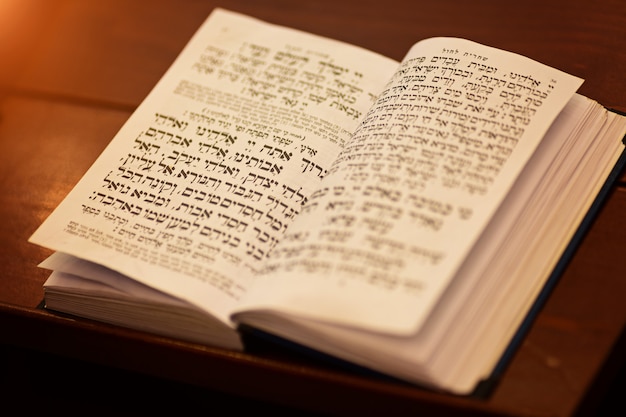 Foto torah scroll è il libro più sacro all'interno dell'ebraismo, libro di preghiere ebraiche sul tavolo