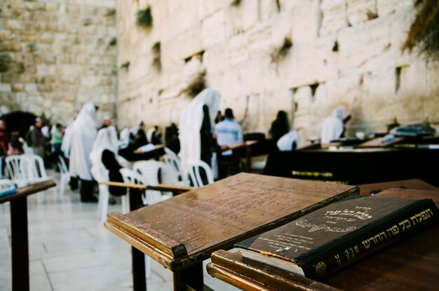 Foto la torah sul tavolo con le persone in piedi vicino al muro dei pianti