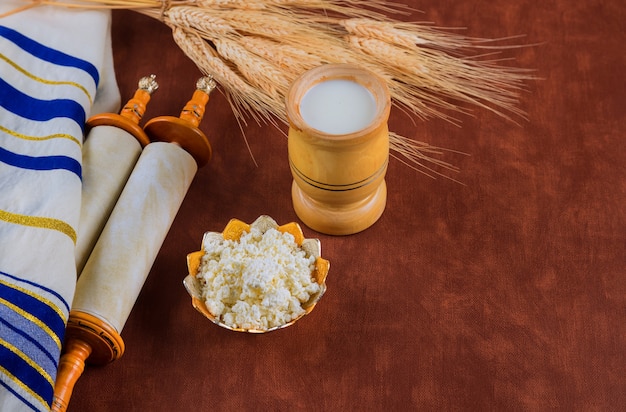 Torah and tallis in the Traditional celebration season Jewish holiday Shavuot on kosher dairy food