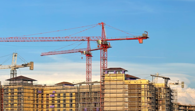 Toren hijskranen op de bouwplaats van hoge residentiële appartementsgebouwen vastgoedontwikkeling