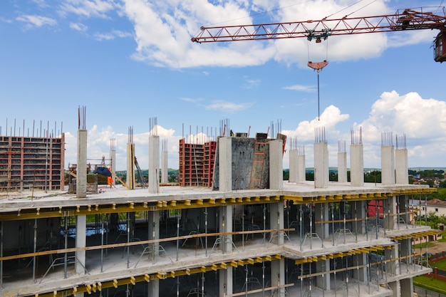 Torenkraan bij hoog betonnen woongebouw in aanbouw. Vastgoed ontwikkelingsconcept.