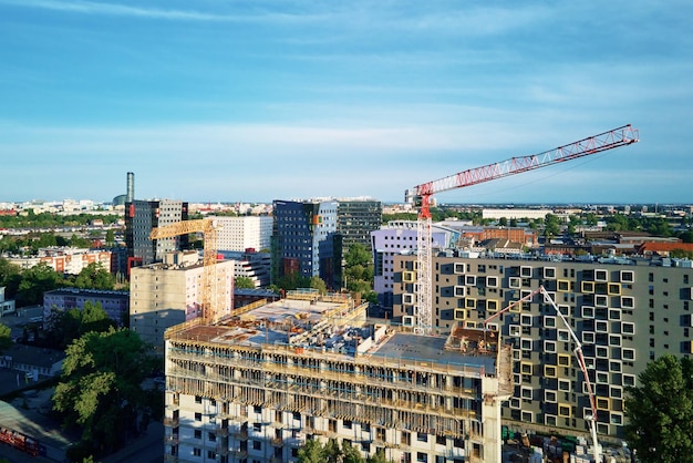 Torenkraan op bouwplaats met woongebouw in aanbouw