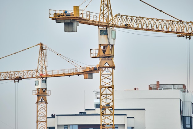 Torenkranen op de bouwplaats van hoge residentiële appartementsgebouwen Vastgoedontwikkeling