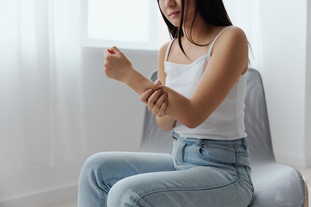 Tormented suffering tanned beautiful young asian woman hurting
holding painful elbow at home interior living room injuries poor
health illness concept cool offer banner