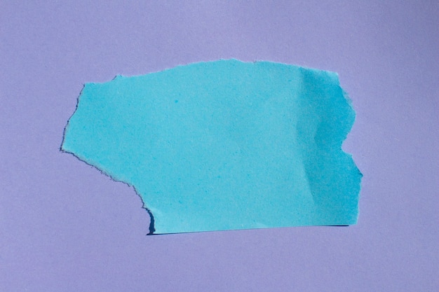 Photo a torn blue paper with a hole in it