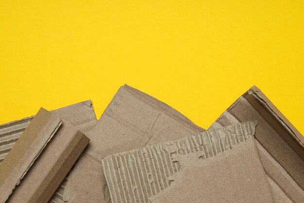 Torn cardboard on a yellow background top view