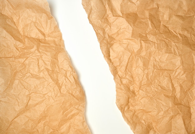 Torn crumpled brown parchment paper, white background