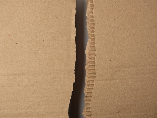 Фото Разорванный пополам коричневый лист бумаги из-под коробки