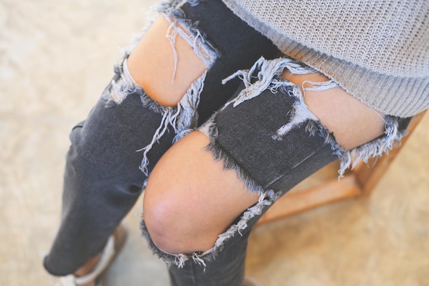 Torn pants torn jeans close up girl wear jean women knees in jeans holes in jeans fashion clothing Hips and knees in fashionable jeans