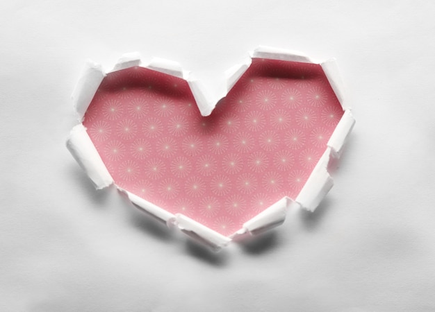 Torn paper heart over colorful background