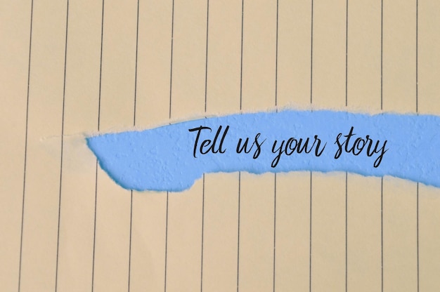 TELL US YOUR STORY というテキストが書かれた破れた紙