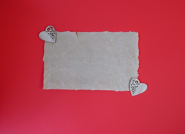 Разорванный листок бумаги на красном фоне. Любовное письмо