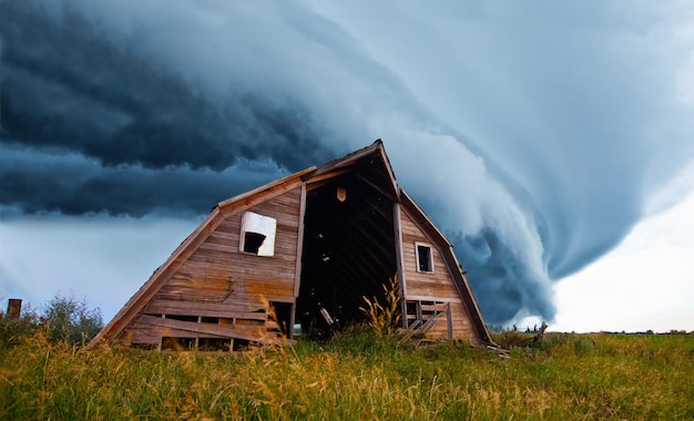 Tornado forming behind old barn