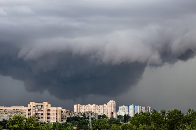 Tornado, onweer, trechterwolken boven de stad.