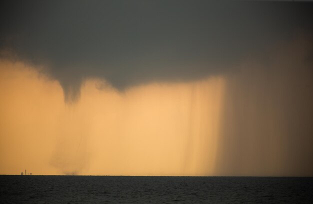 Tornado in the sea during the day against the sky