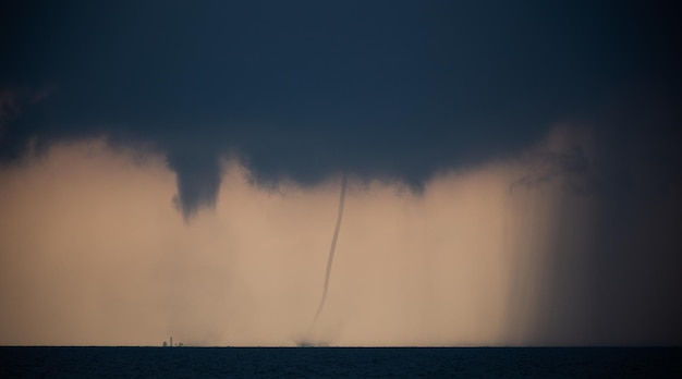 Tornado in the sea during the day against the sky