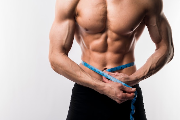 Photo torso of shirtless athletic man with measurement tape