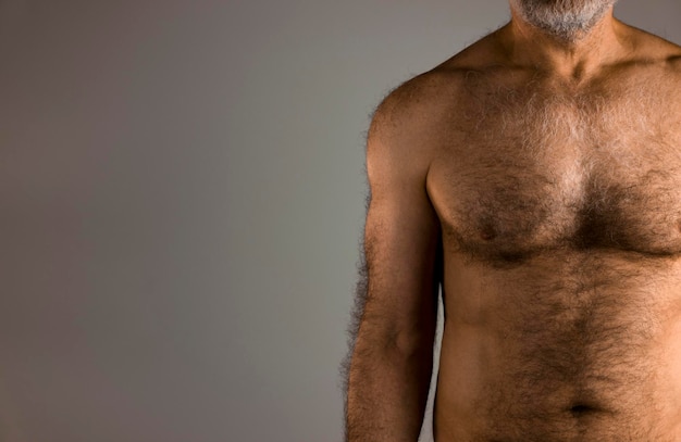 Torso of shirtless hairy man against white background
