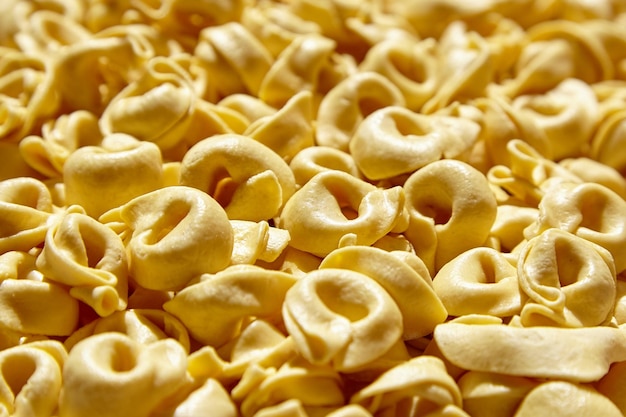 Tortellini pasta food background Fresh Tortellini with raw prosciutto Italian stuffed pasta