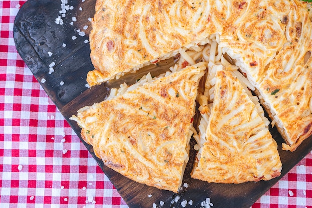 Tortilla de fideos in spaanse of noedelomelet geportioneerd op een houten bord. luchtfoto. neem landschap. detailopname.