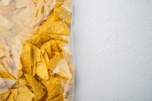 Tortilla Mexican nachos  chips in a plastic  bag, on white table, top view or flat lay