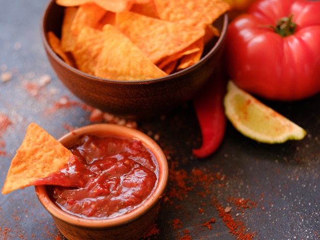 Tortilla nacho chips in een kom. heerlijke bierjager. beste eten voor een snelle snack. driehoekige knapperige plak gedoopt in salsa tomatensaus